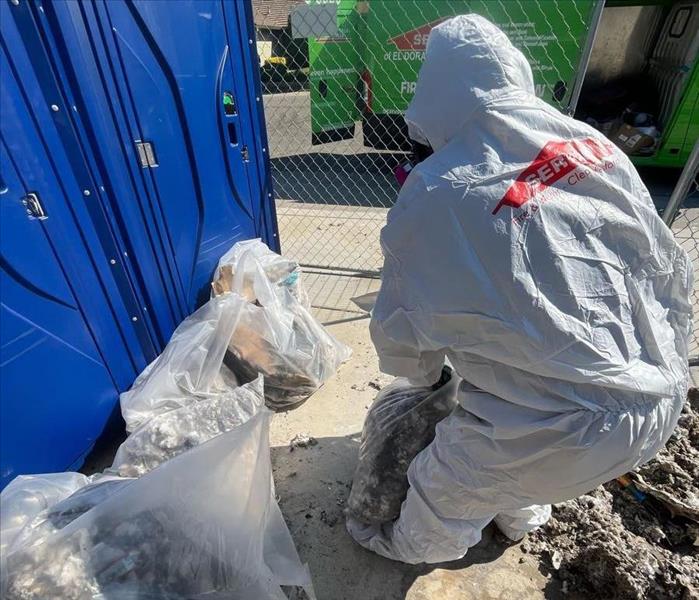 Man in PPE removing demo trash