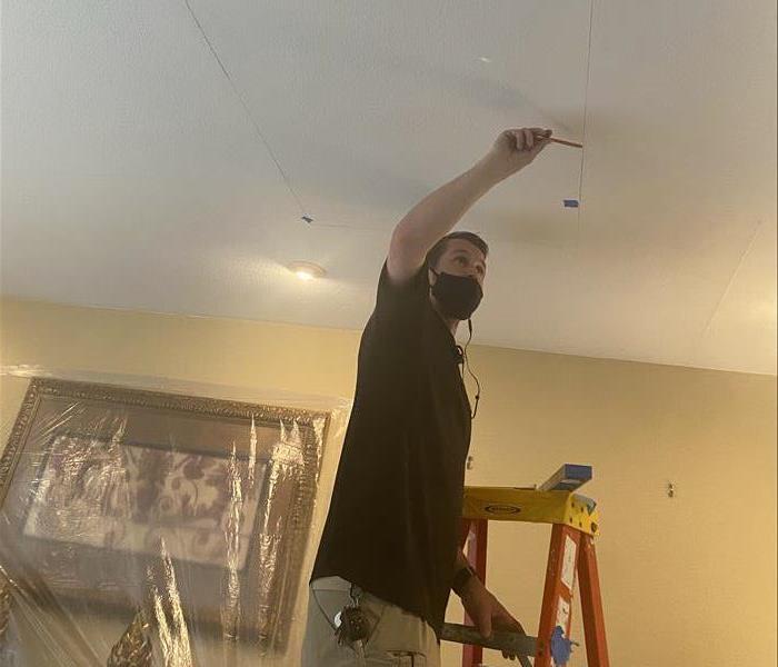 male on ladder cutting out white ceiling in Sacramento